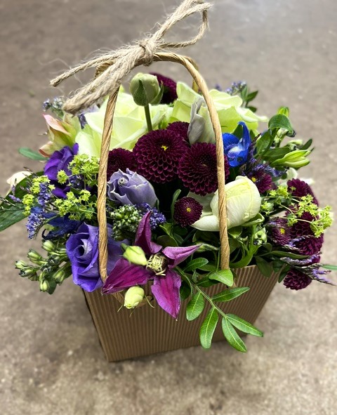 Tasken der sprudler af blomster og vil glæde enhver modtager